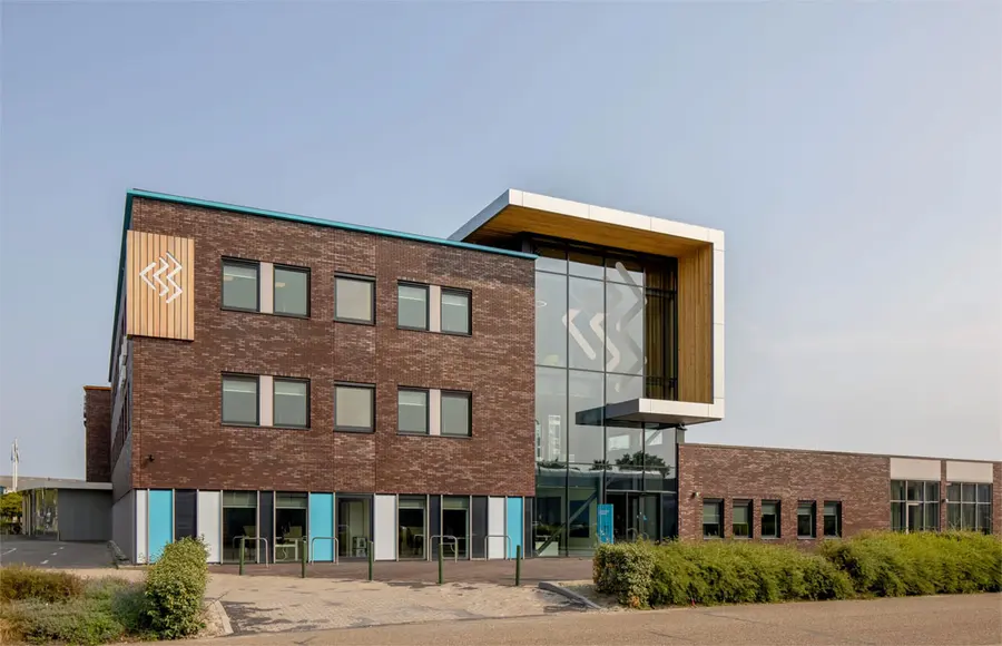 Het kantoorpand van Beveland Wonen, bakstenen gevel met een glazen entree.