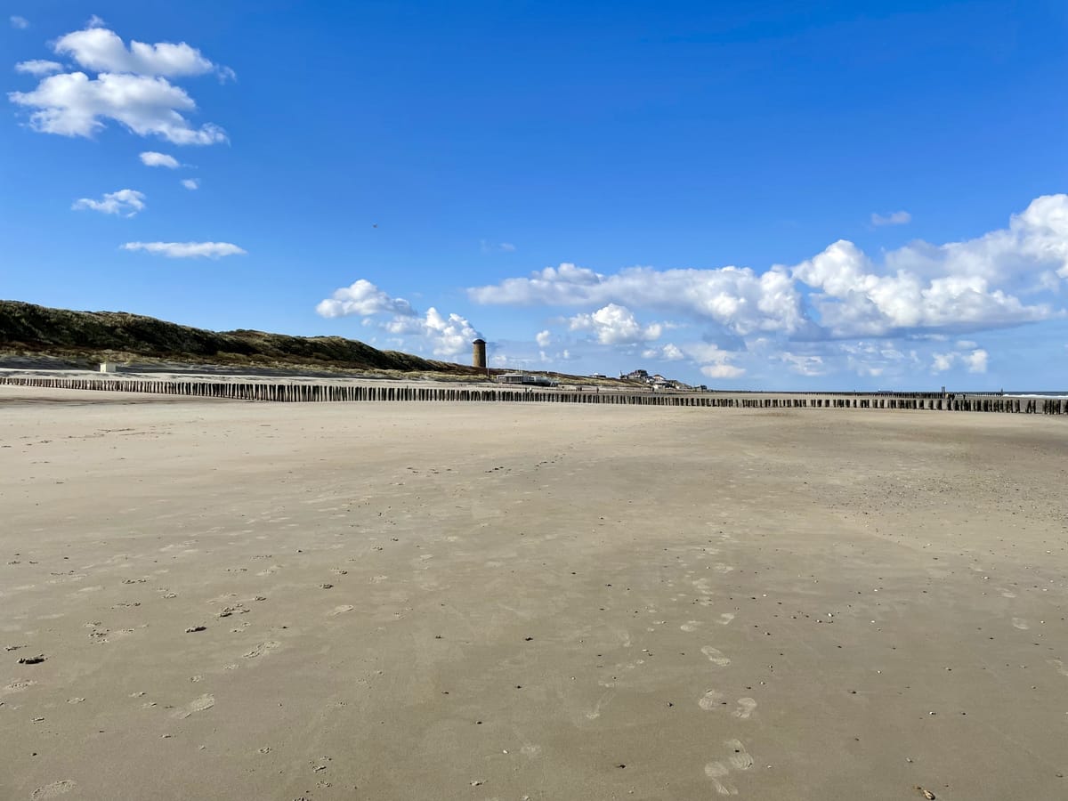 Het brede, vrijwel lege strand bij Domburg met een baken in de verte