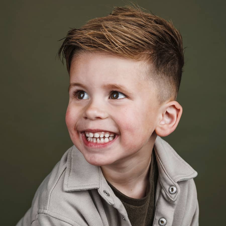 Jongen met een brede lach tegen een olijfgroene achtergrond