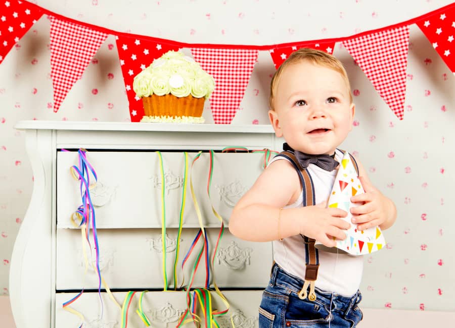 Peuter met slingers en een taartje tijdens een smashcake shoot