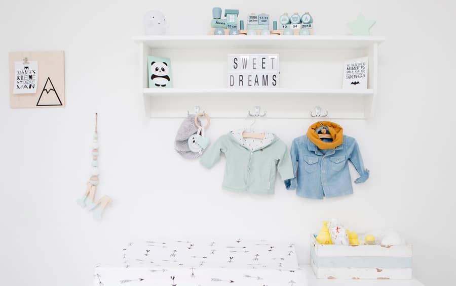 Plank met babykleertjes en decoratie in de studio