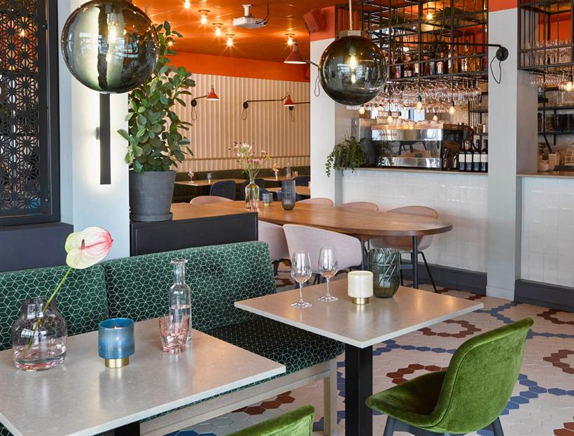 Groene bank en rookglazen bollampen in het restaurant