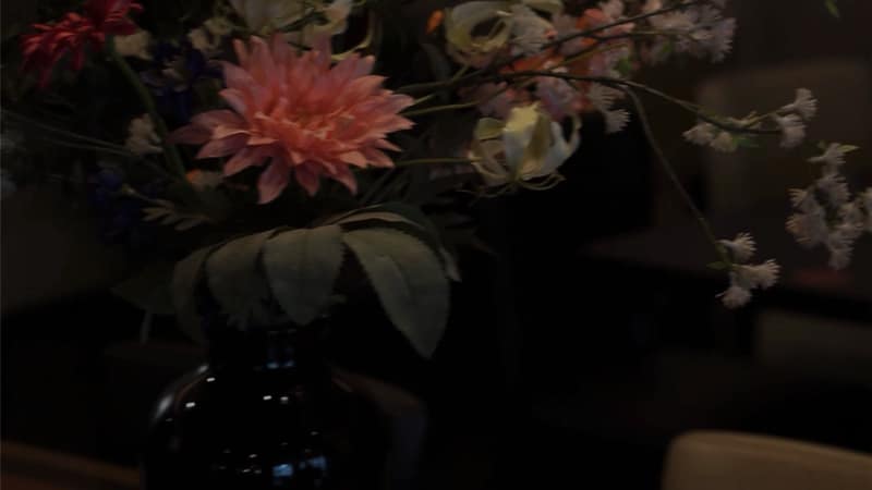 Boeket bloemen in een donkere vaas op tafel