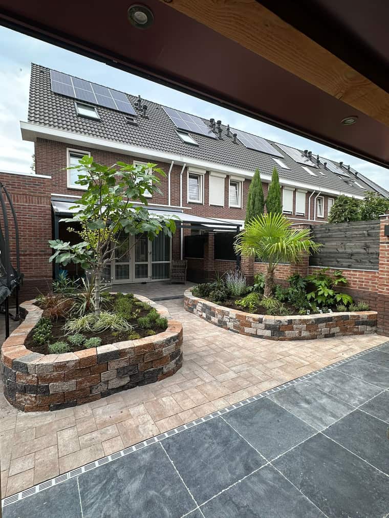 Terras met natuurstenen plantbakken en twee soorten tegels