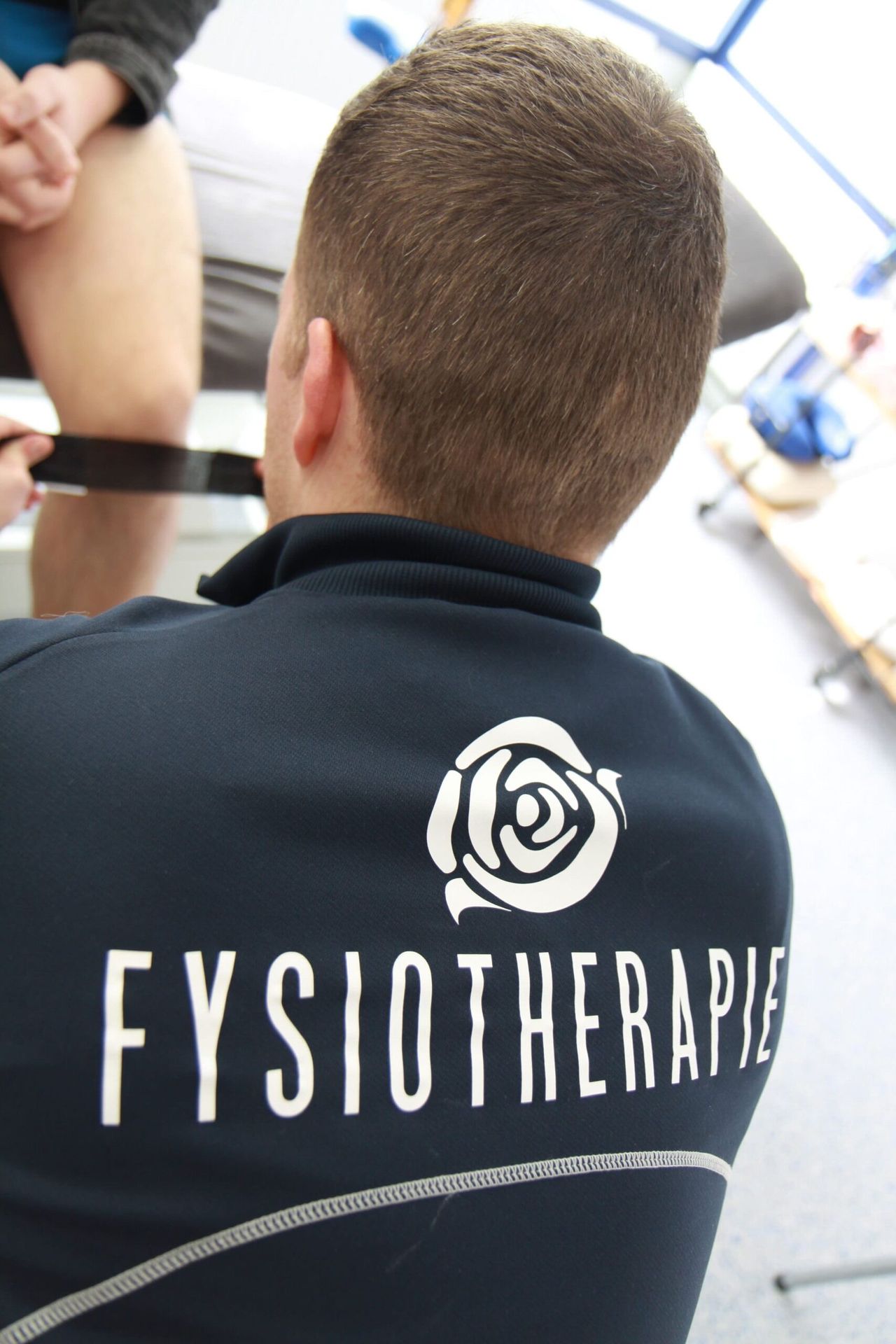 Patiënt traint op de crosstrainer onder begeleiding
