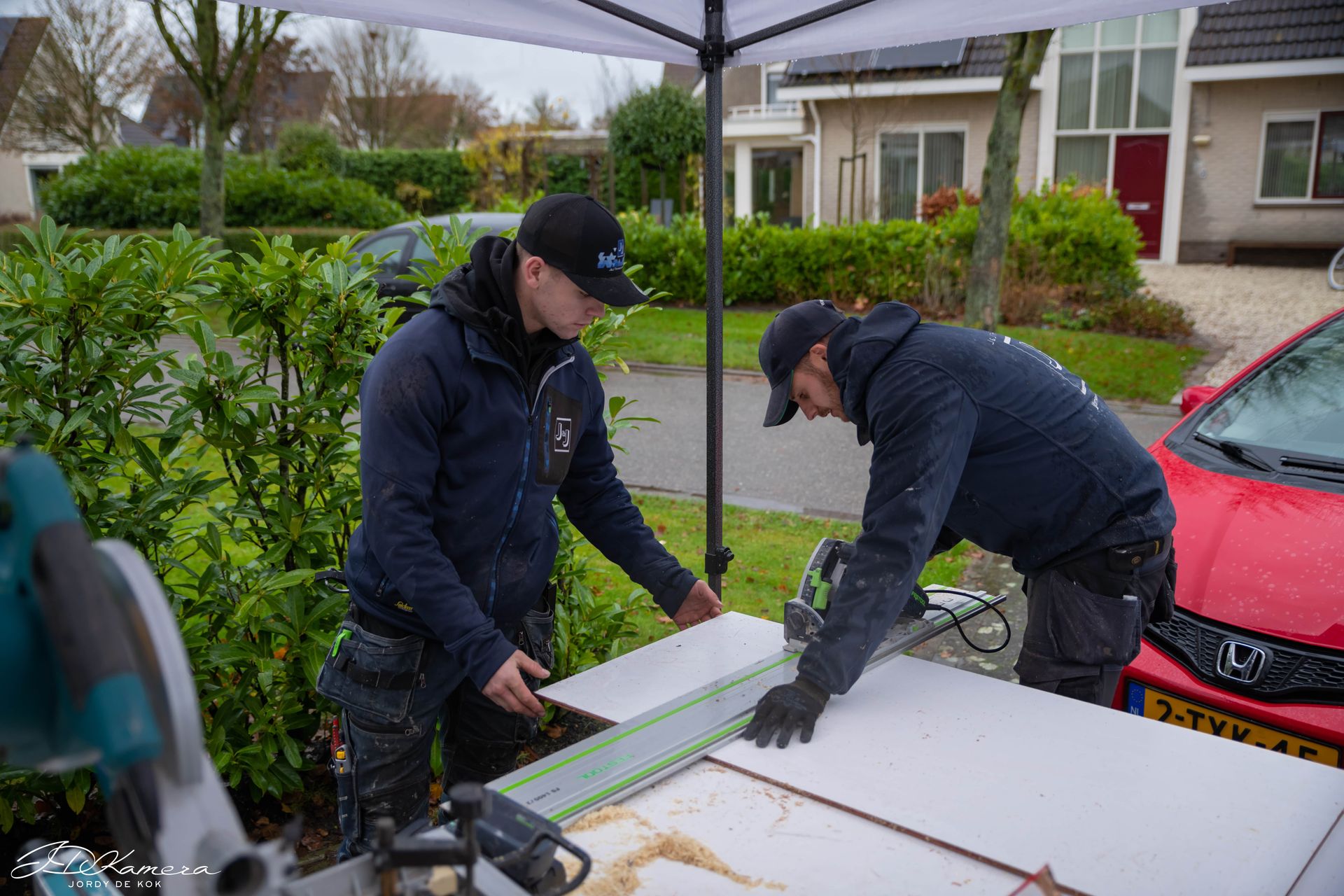 Twee vakmensen van J & J Timmerwerken zagen een plaat op locatie