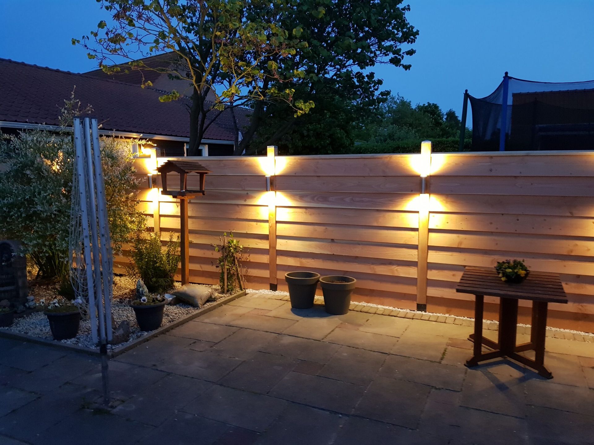 Zelfgebouwde tuinschutting met sfeerverlichting in de avond