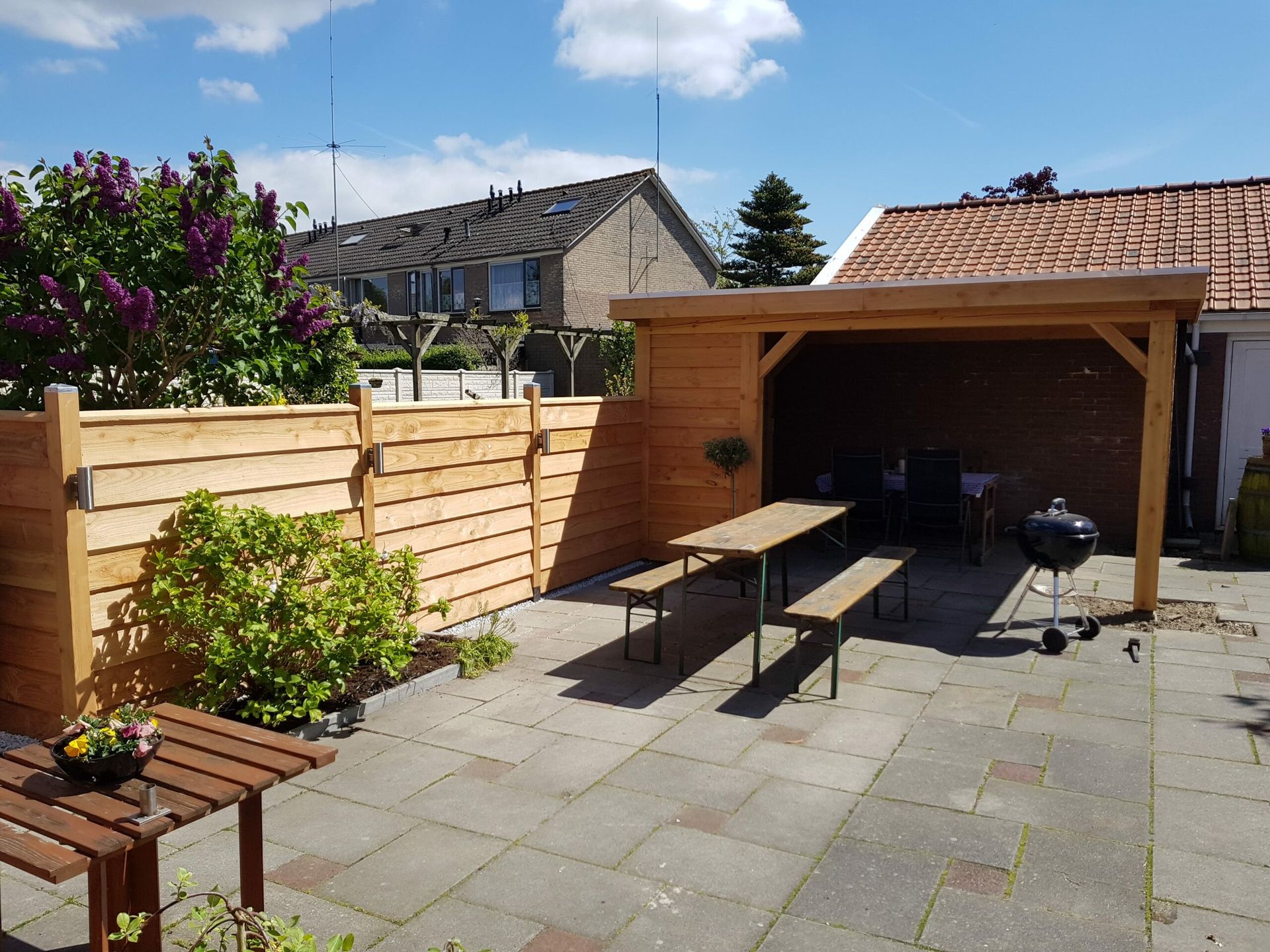 Houten veranda gezien vanaf de tuin, met houten poort