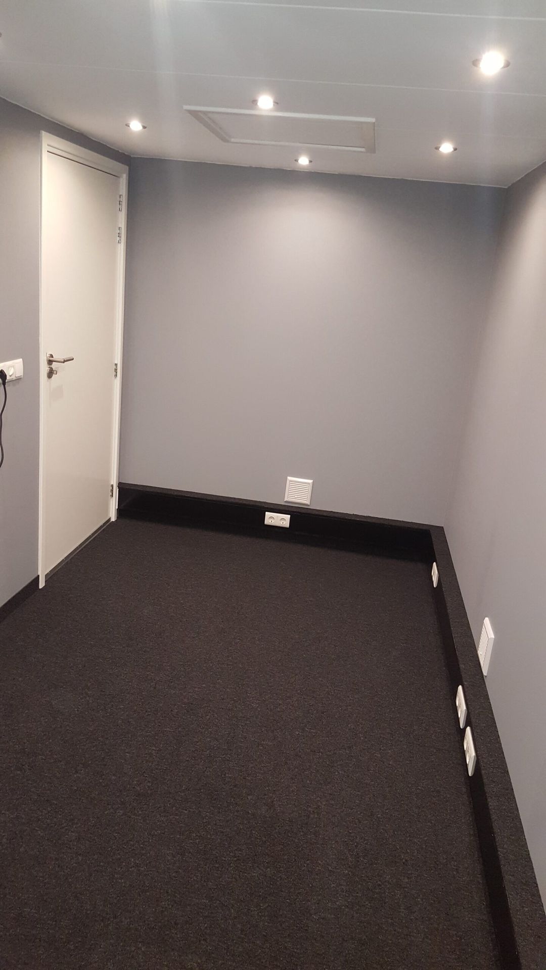 Muziekstudio met donkere vloerafwerking en ventilatieroosters