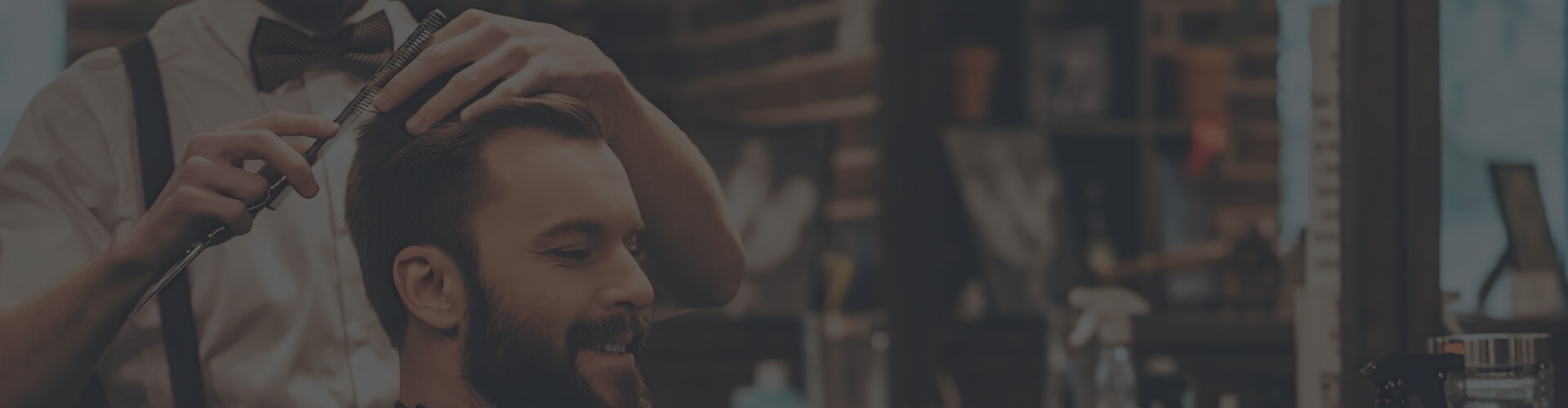 Barbier kamt en knipt het haar van een klant in de stoel bij Prince Barbershop