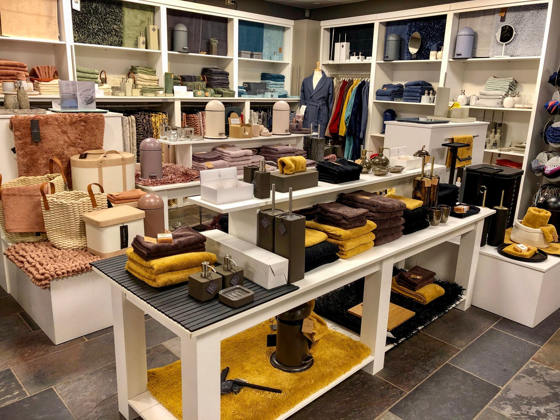 Presentatietafels in de winkel met textiel, tassen en woonaccessoires
