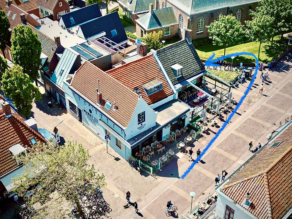 Luchtfoto van Markt Zes aan de Markt in Domburg, met het terras en de kerk ernaast
