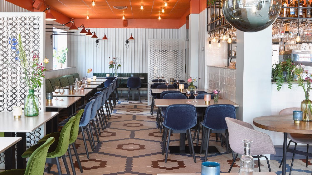 Het restaurant gezien vanaf de bar met de tegelvloer op de voorgrond