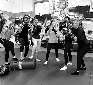 Groep deelnemers met bokshandschoenen tijdens de bokstraining